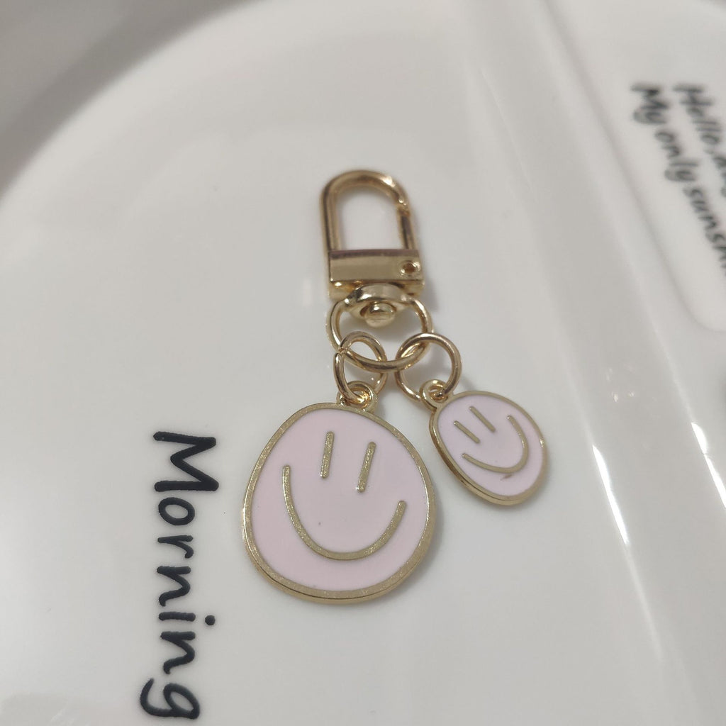 Cross-border e-commerce alloy color dripping smiley face keychain electroplated gold irregular expression bag pendant accessories