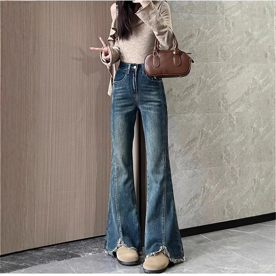 Women's stylish denim jeans, stretchy blue-gray with frayed edges, slit, high-waisted, leg-lengthening, flared
